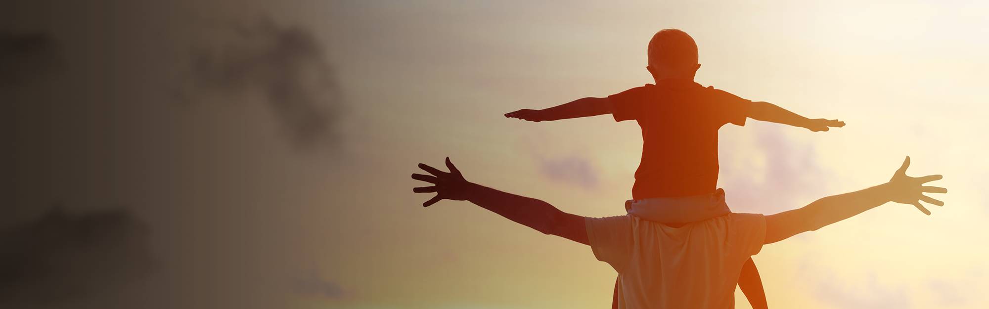 Child sitting on his father's shoulders