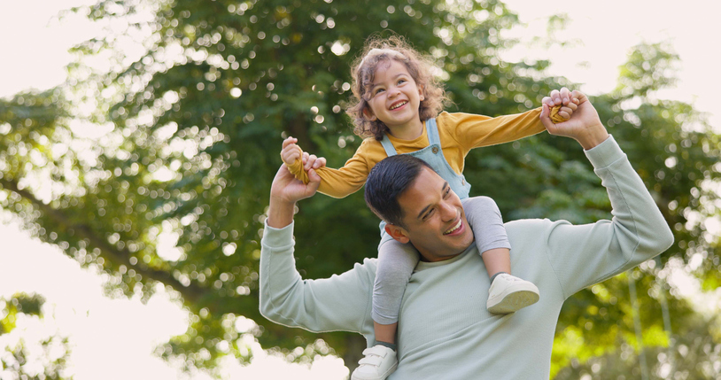 father carrying daughter on his shoulders