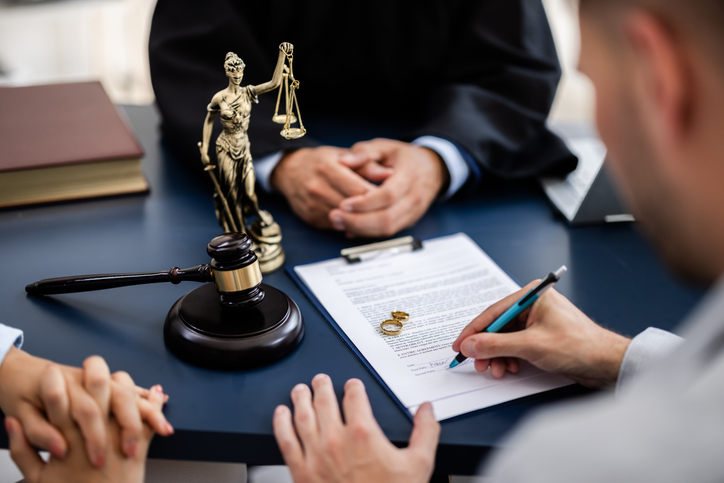 divorcing couple signing a document with a lawyer